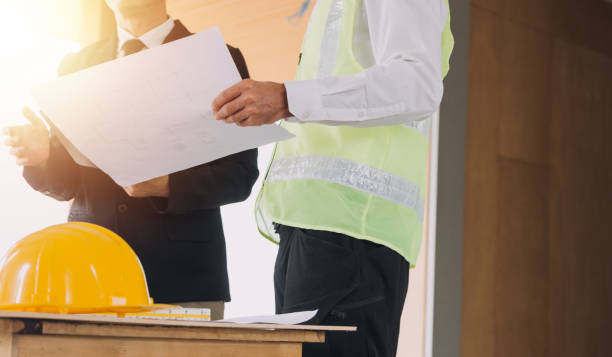 Two business man construction site engineer. Engineering objects on workplace with partners interacting on background
