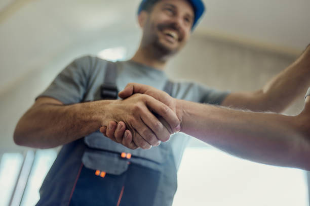 Close up of manual workers greeting with a handshake during home renovation process.