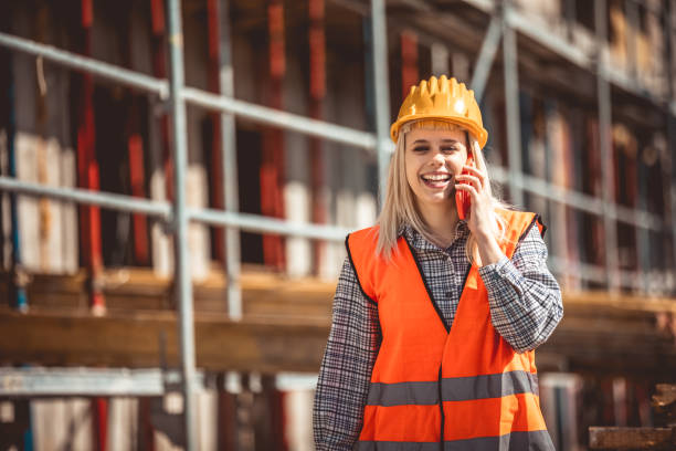 Architect woman using phone and happy on construction site in industry, planning and inspectioning
