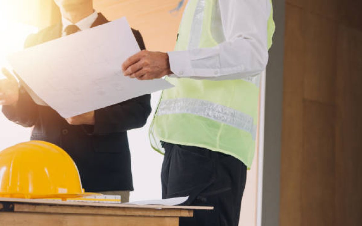 Two business man construction site engineer. Engineering objects on workplace with partners interacting on background