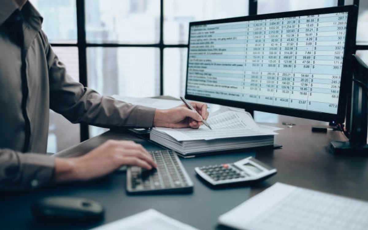Investors working on desk office and using a pan and pointing to check tracking cost, balance, profit and  currency. Accounting and  Financial concept.